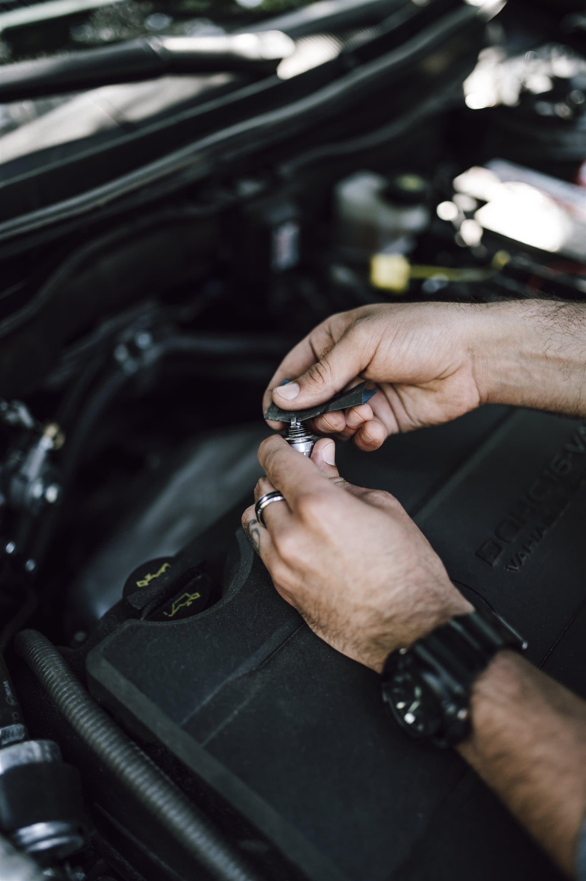 Mechanic inspecting an engine bay during vehicle service and recall work